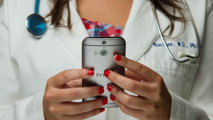 Female doctor holding a cell phone