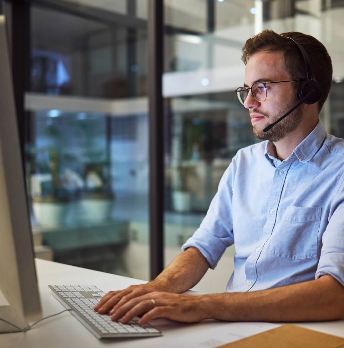 Man working on a desktop with a headset on