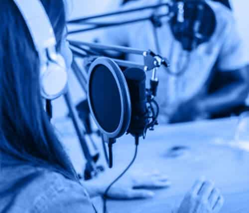 Person in a recording studio using a microphone