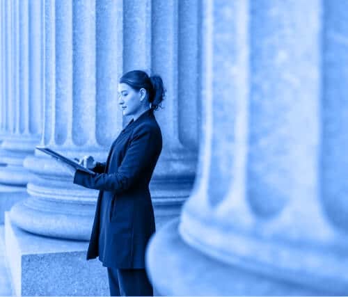 Woman standing in front of a government building using a tablet