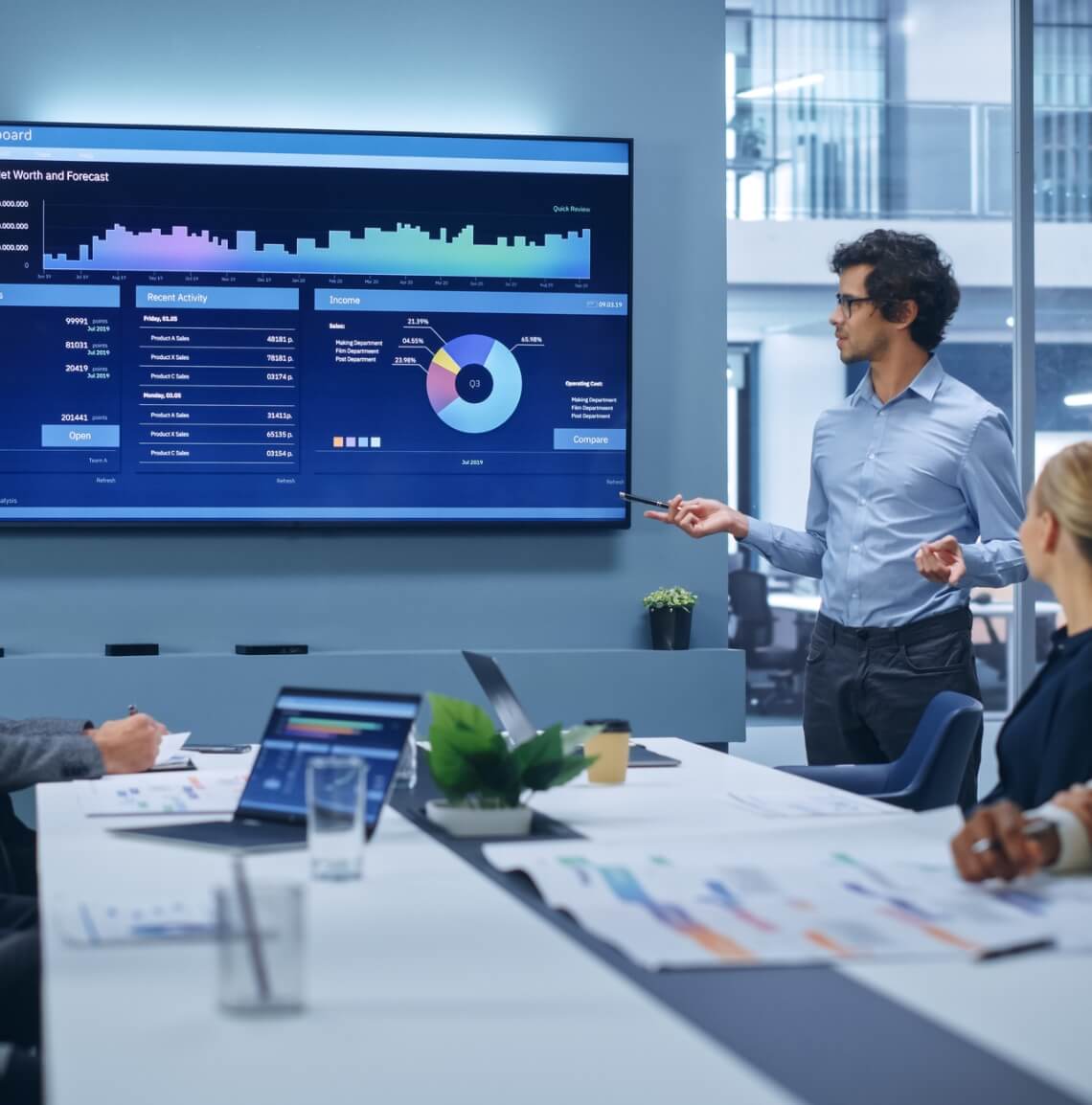 Man giving a presentation with graphs in a conference room