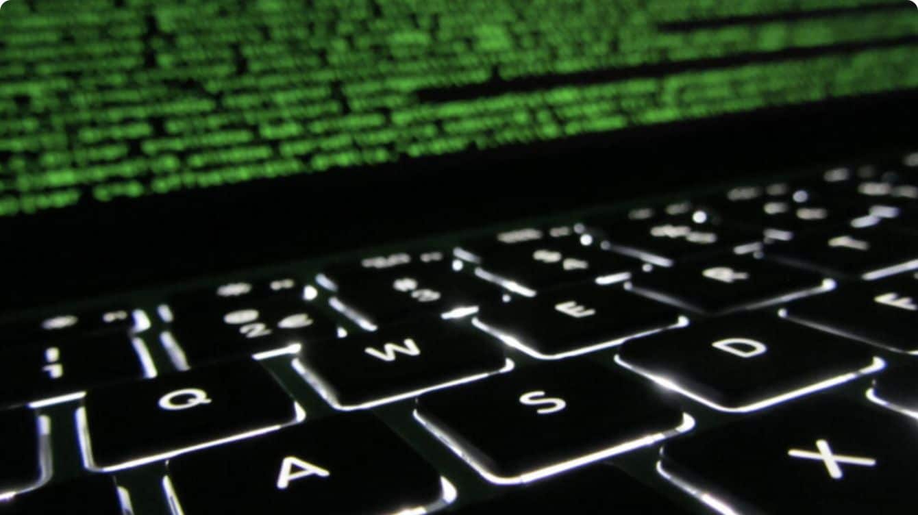 Close up view of laptop keyboard and screen with binary code on it