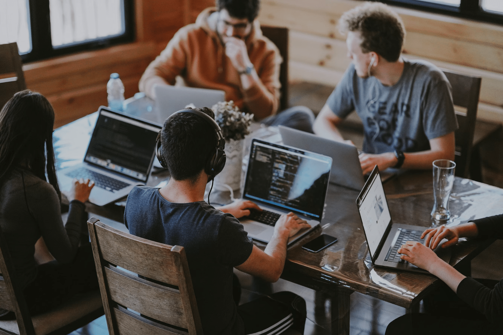 Group of people working in a shared space while wearing headphones