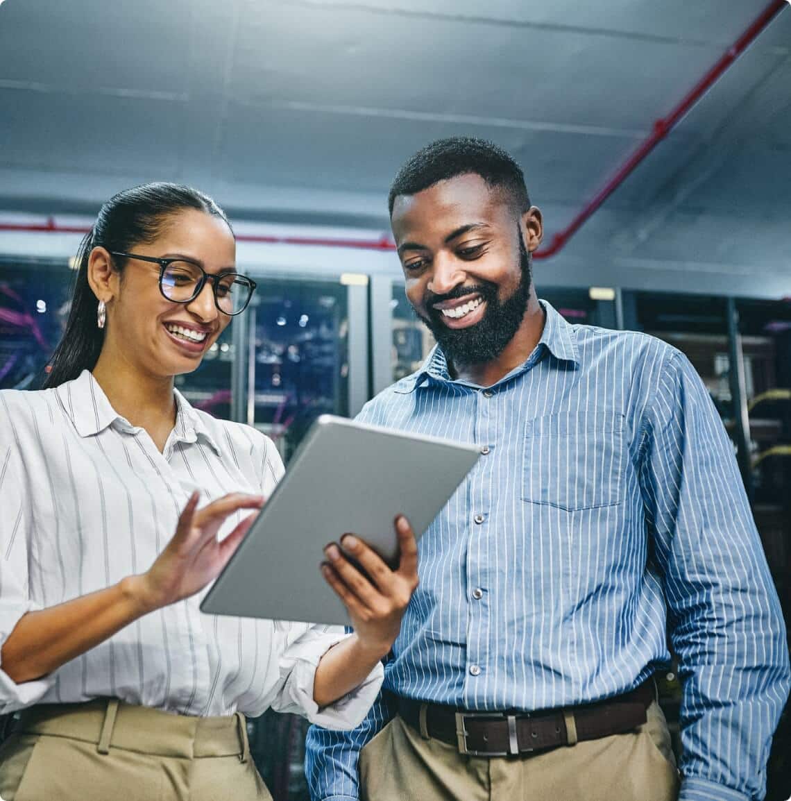 Two employees using a tablet and smiling